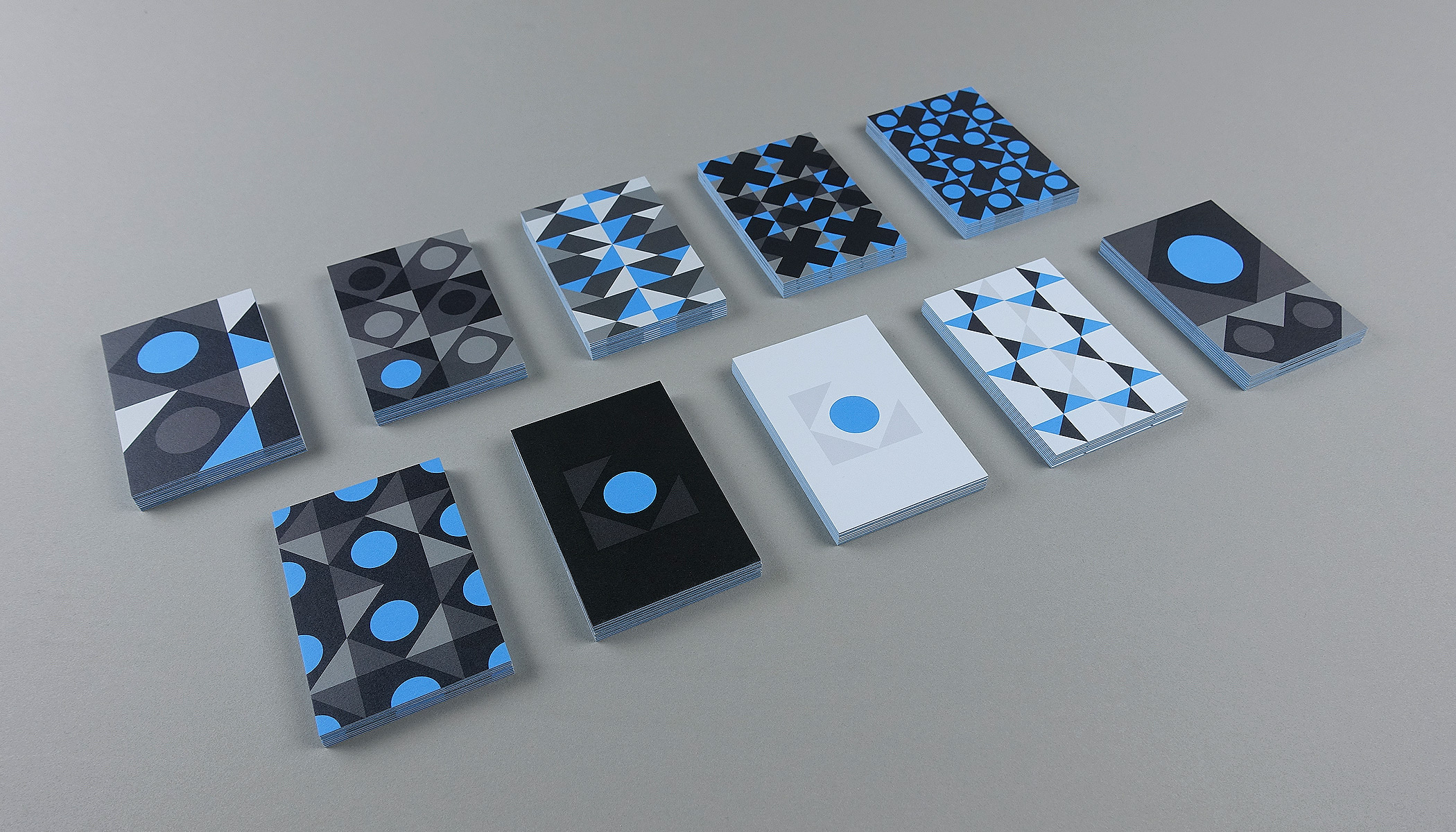 2 rows of stacked business cards showing 10 different front designs