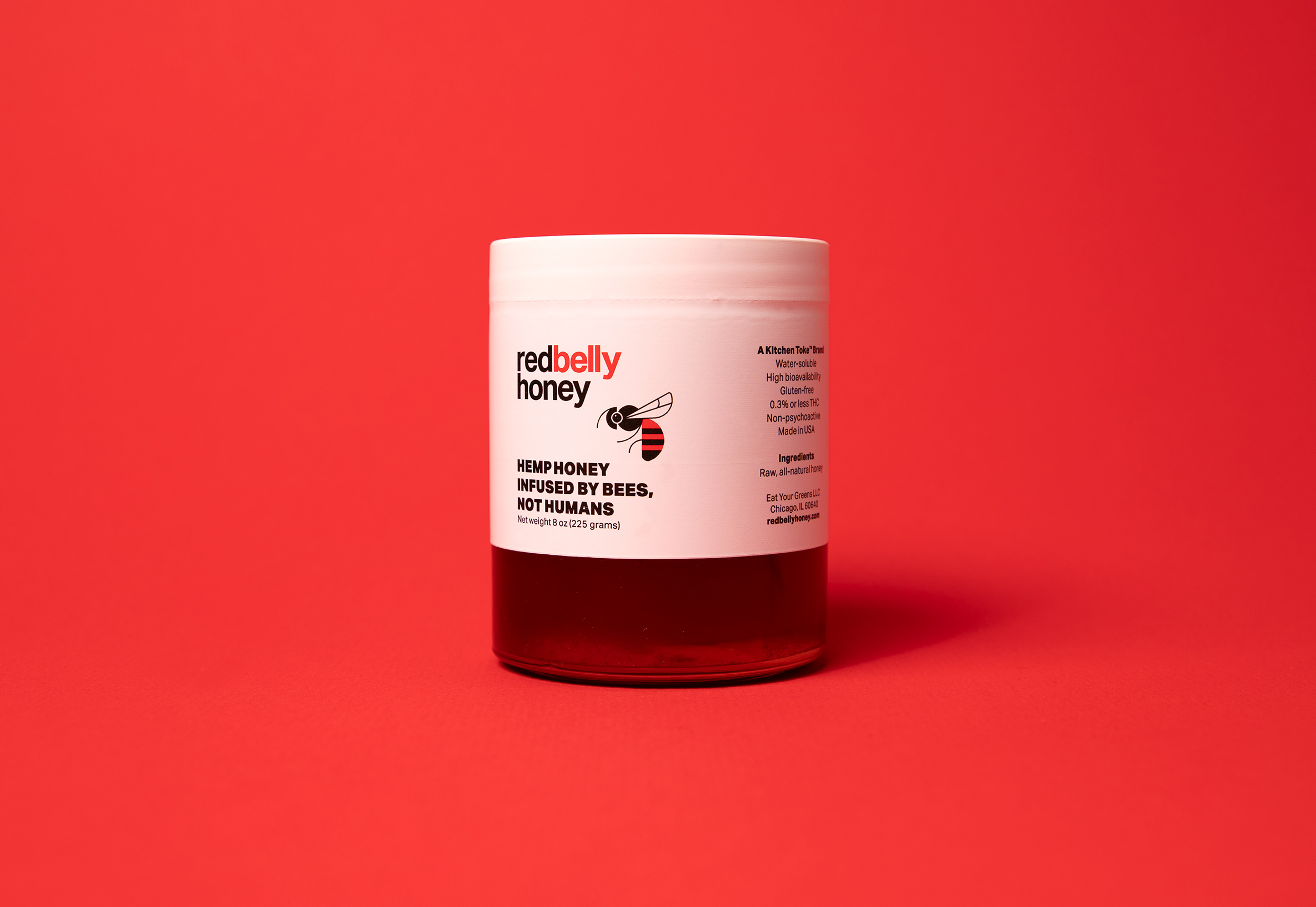 jar of red belly honey on red backdrop