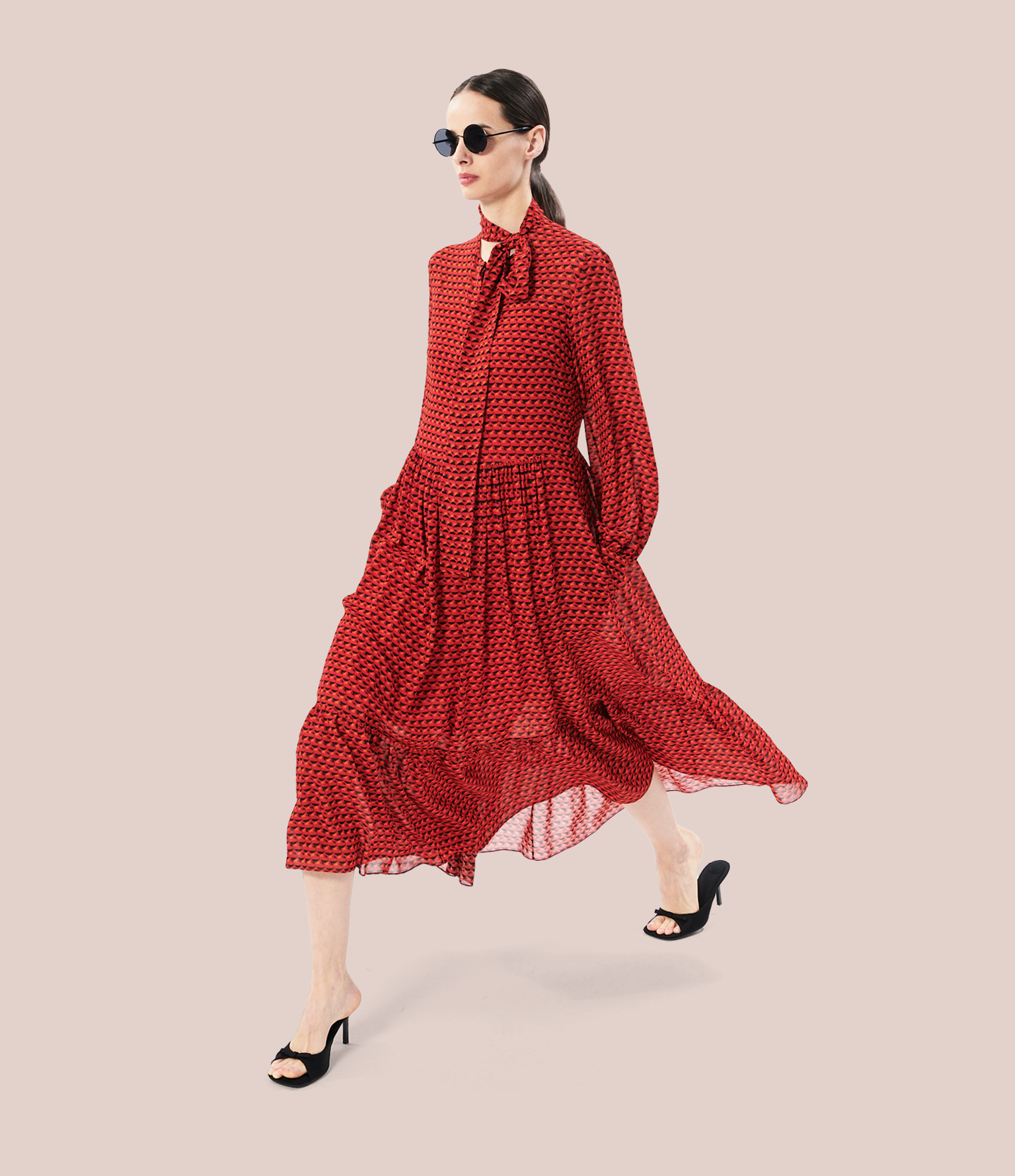 brunette model wearing a red dress with bird print