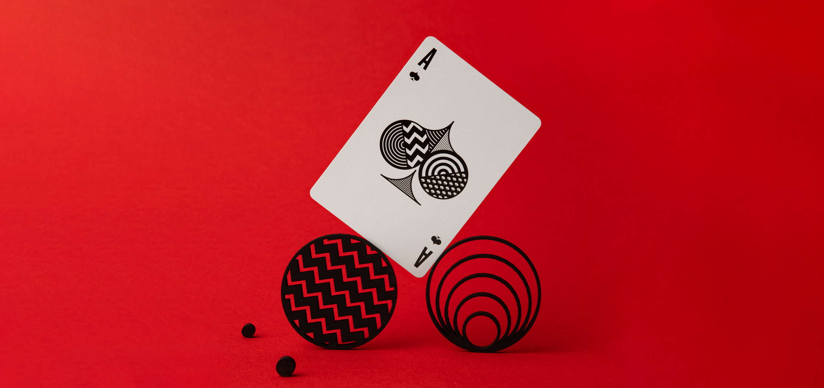 ace of spades balancing on 2 black circles red background
