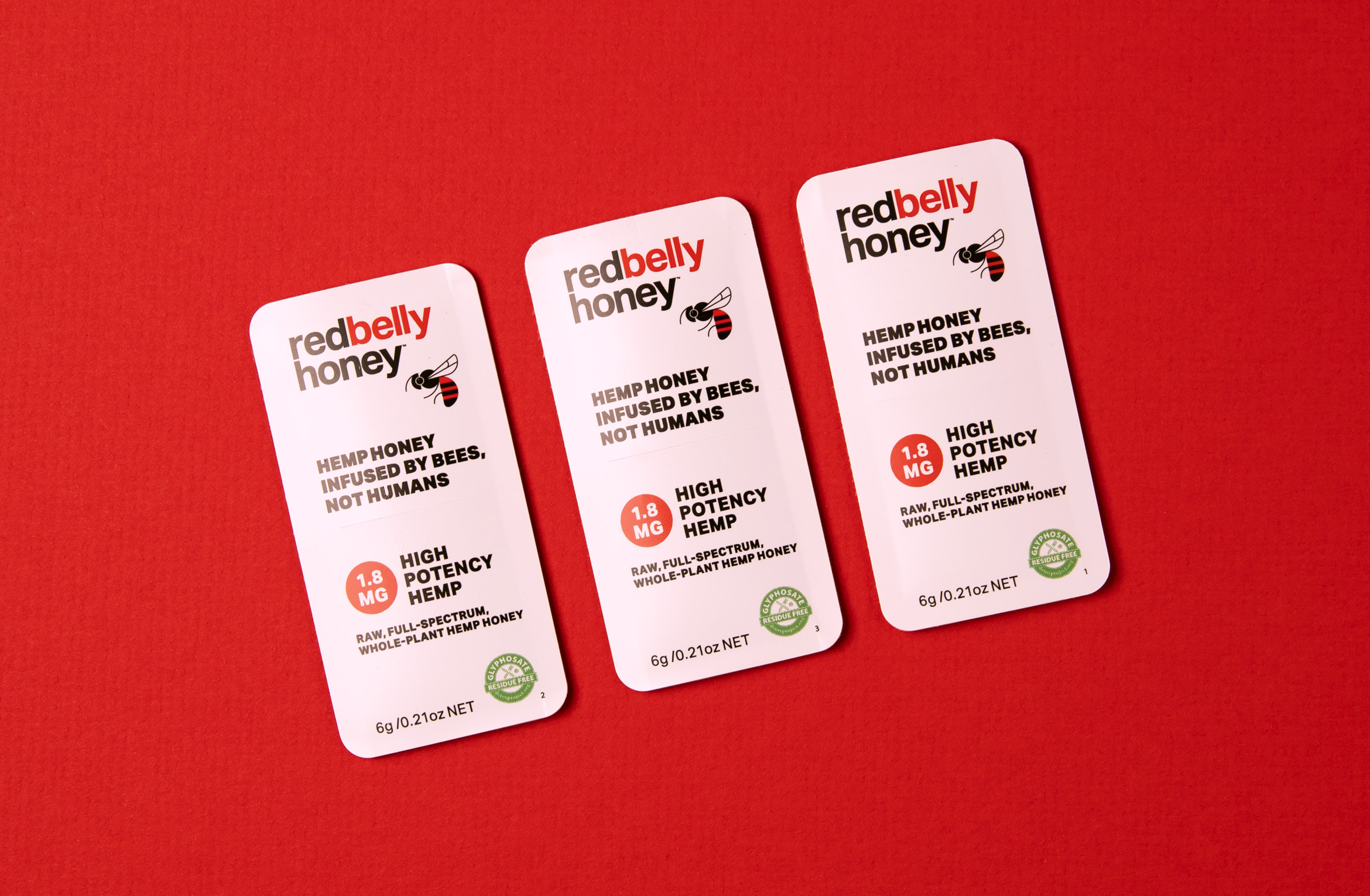 3 single serving honey paks in a row on red